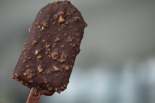 Brown chocolate popsicle ice cream  covered with chocolate mix peanut, close up