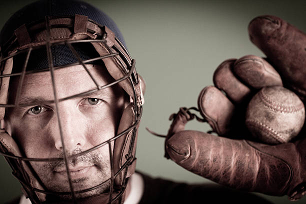 Vintage Baseball Player in Catching Stance with Ball and Mitt