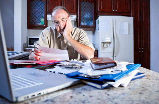 A senior man stresses about finances and taxes.Please browse: