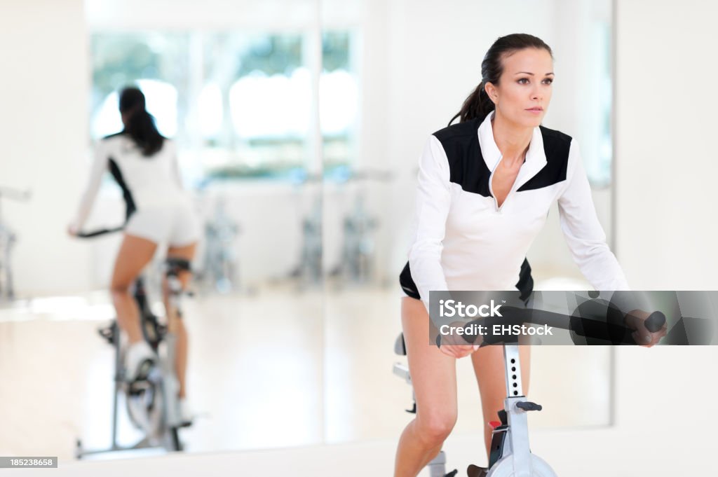 Молодая женщина фитнес на спиннинг велосипед модели Staionary в тренажерный зал - Стоковые фото 20-29 лет роялти-фри