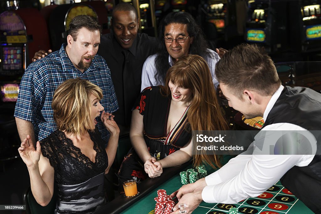 Grupo diversificado de pessoas jogando roleta no Casino - Foto de stock de Roda de roleta royalty-free