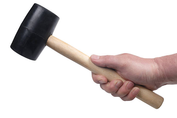 Mallet "Male hand holding a rubber headed, wooden handled mallet, isolated on white." rubber mallet stock pictures, royalty-free photos & images