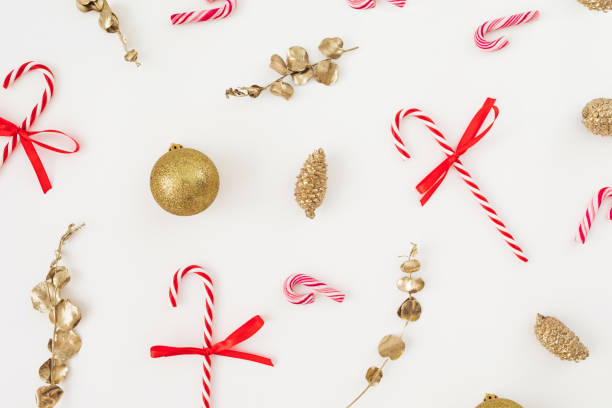istock Xmas composition with golden decoration and candy canes on white. Flat lay, top view 1852396327