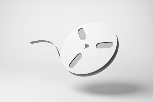White tape reel floating in mid air on white background in monochrome and minimalism. Illustration of the concept of reel-to-reel audio tape recording and computer data storage