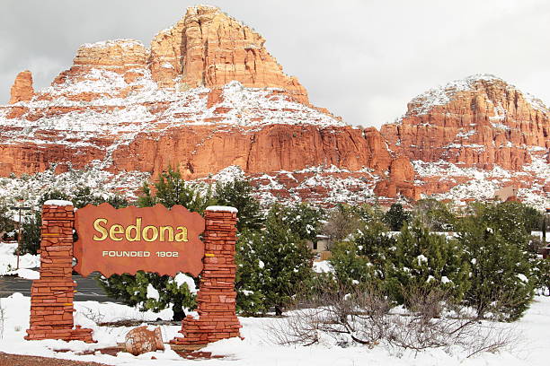 Sedona Red Rock Sign Snow A winter scene at the entrance to Sedona Arizona.  On the right is The Chapel of the Holy Cross which is a Catholic chapel belonging to the Parish of Saint John Vianney and the Roman Catholic Diocese of Phoenix. It was built directly into a butte and offers a spectacular view of the valley 200 feet below. One of most visited churches in Sedona. outcrop stock pictures, royalty-free photos & images