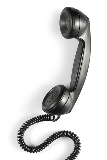 Antique phone handset with cord in the color black Vintage black telephone receiver on white background telephone receiver stock pictures, royalty-free photos & images