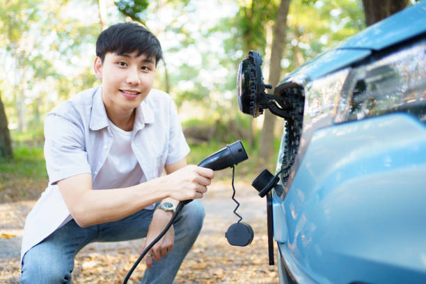 istock Man charging EV car at public charging station. 1852401161