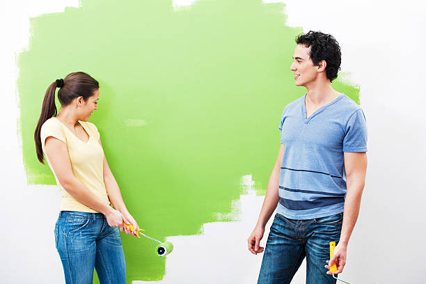 istock Cheerful couple painting the wall 185240320