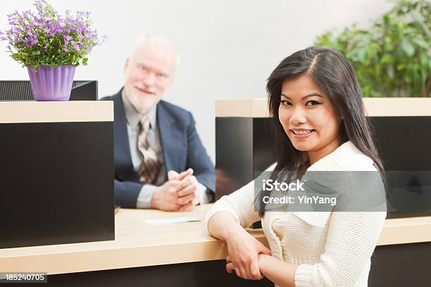 Happy Asian Retail Banking Customer In Front Of Bank Teller Stock Photo - Download Image Now