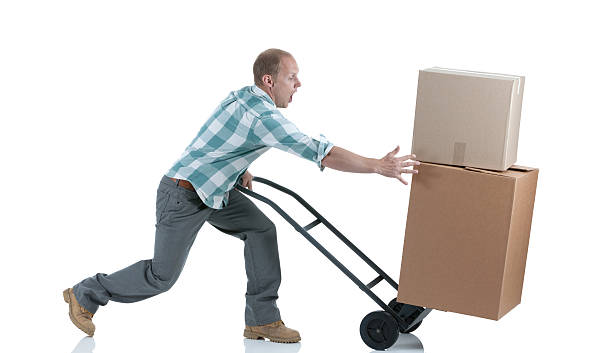 Man carrying cardboard boxes in a warehouse Man carrying cardboard boxes in a warehouse unbalance stock pictures, royalty-free photos & images