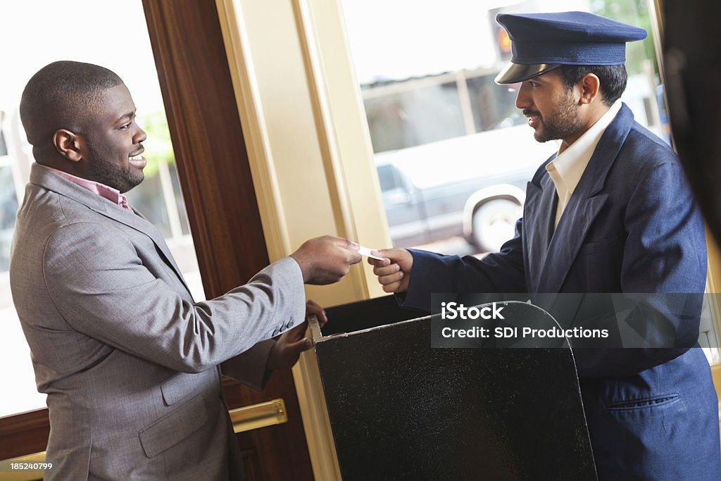 Homme d'affaires donnant hôtel du ticket de stationnement avec voiturier pour récupérer son véhicule - Photo de Valet personnel libre de droits