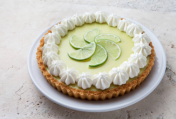 key lime pie mit schlagsahne rosetten und limetten in scheiben. - key lime pie dessert pie pastry stock-fotos und bilder