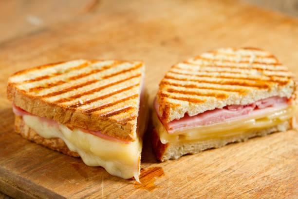 Panini Sandwiches "Hot off the grill panini sandwiches made with crusty, hand sliced bread, black forest ham and swiss cheese." ham and cheese sandwich stock pictures, royalty-free photos & images
