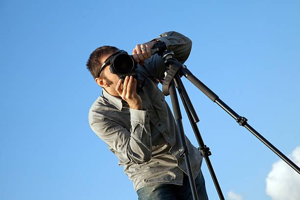 istock young photographer with the camera on a tripod. 185242314