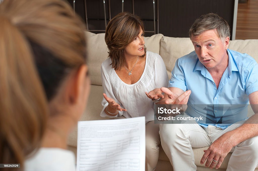 Pareja discutiendo en una sesión de asesoramiento médico - Foto de stock de Terapia - Tratamiento médico libre de derechos