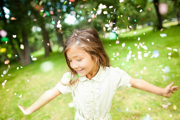 istock Girl In Park With Colorful Confetti Falling on Her 185243193