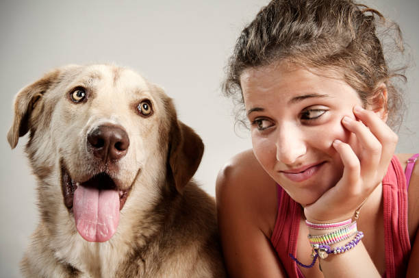 Portrait of a teenager girl with a dog in a park.