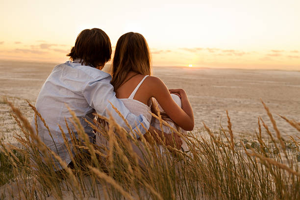 istock Couple Looking at Sunset On Beach 185243502