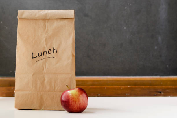 istock Brown paper lunch bag, red apple and chalkboard 185243706