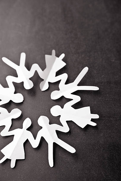 istock White paper chain of people in a circle on black background 185243809