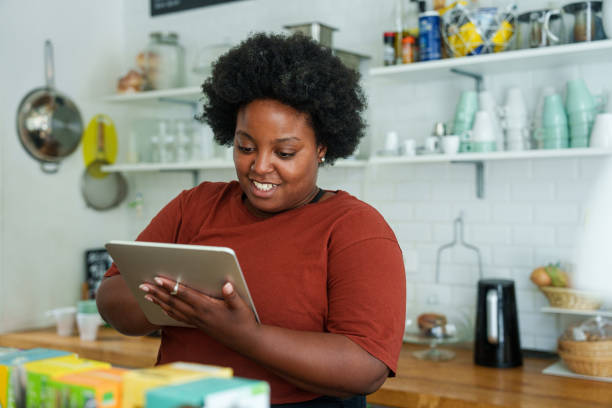 istock Mid-shot of African-American woman using digital tablet while browsing inside garage sale 1852441536