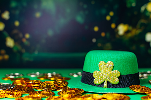 Happy St Patrick's Day, leaf clover, gold coins, leprechauns hats on green background.