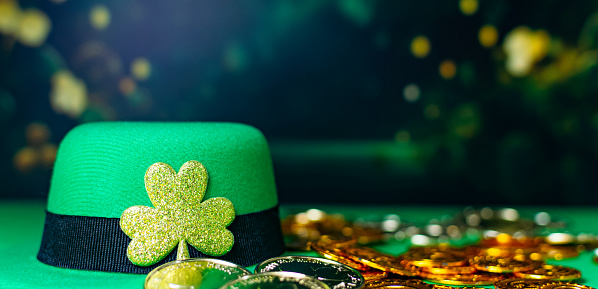 Happy St Patrick's Day, leaf clover, gold coins, leprechauns hats on green background.