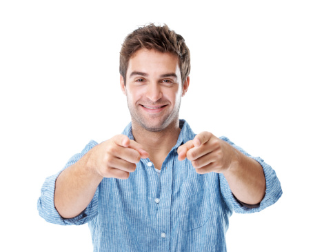 Handsome young man pointing at you while standing isolated on white and smiling - portrait