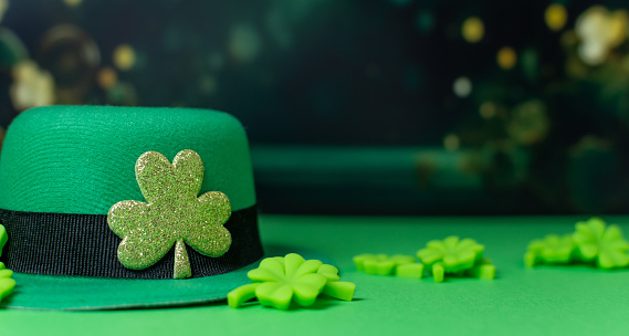 Shamrocks and leprechaun hats on green background with Copy space.