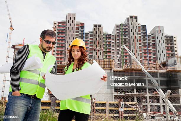 Photo libre de droit de Ingénieurs Sur Site De Construction Plan De Vérification banque d'images et plus d'images libres de droit de Adulte