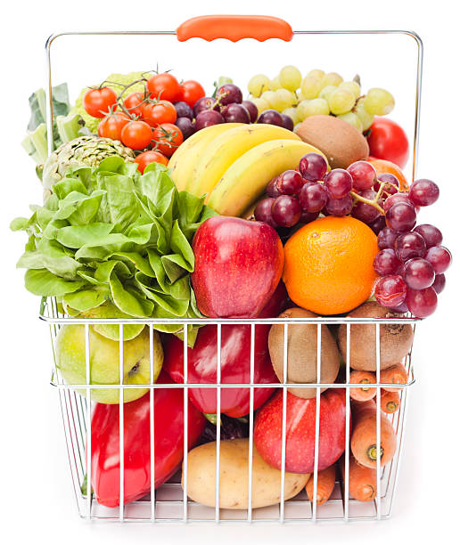 Shopping basket with assortment of fruits and vegetables on white background