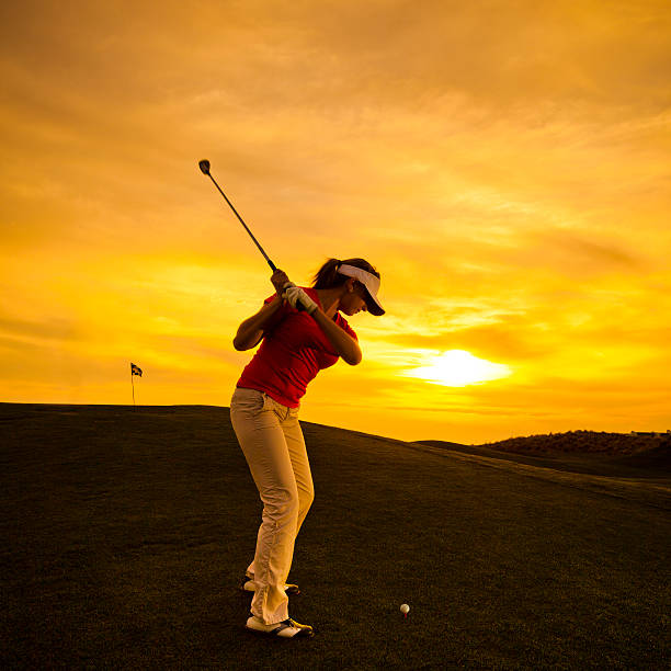 istock Woman golfer swinging at sunset 185245868