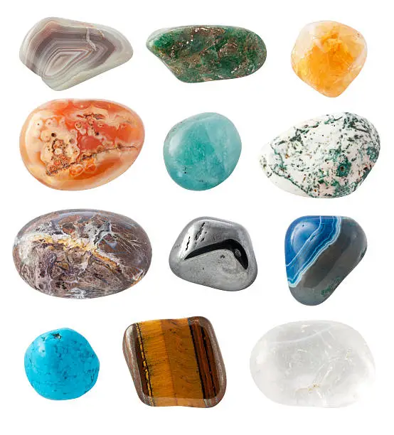 "Semi-precious Gems on white background. From left to right: Agate, Opal, Citrine, Agate, Fluorite (fluorspar), Moss Agate, Ocean Jasper, Hematite, Blue Agate, Howlite, Tiger's eye, Quartz."