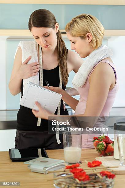 Woman Writing Down Amigo Del Peso En Un Cuaderno Foto de stock y más banco de imágenes de 25-29 años - 25-29 años, Adulto, Adulto joven