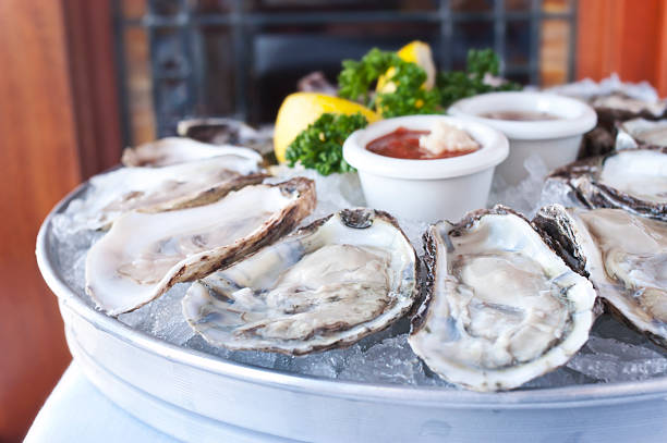 Oysters Half Shell Fresh Oysters over ice. OYSTER stock pictures, royalty-free photos & images