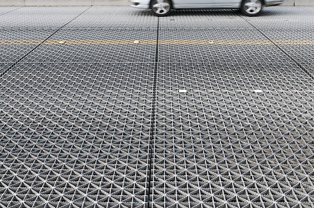 istock Car crossing grated steel deck of drawbridge 185247341