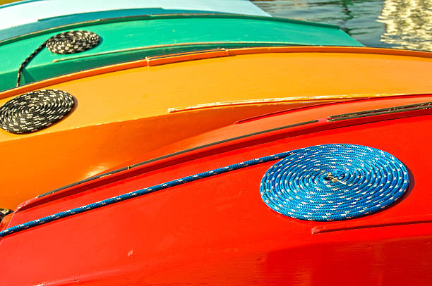Ropes coiled on hulls of rental sailboats at lakeside park