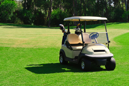 A golf cart at the beautiful green course.