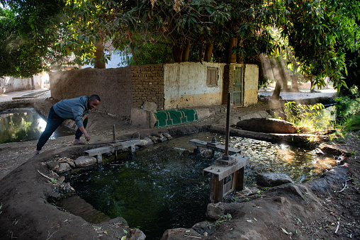 Aswan, Egypt. 9th December 2020 \nA Nubian man controls a sluice gate that channels water from the River Nile to agricultural land on Elephantine Island, Aswan, Egypt.