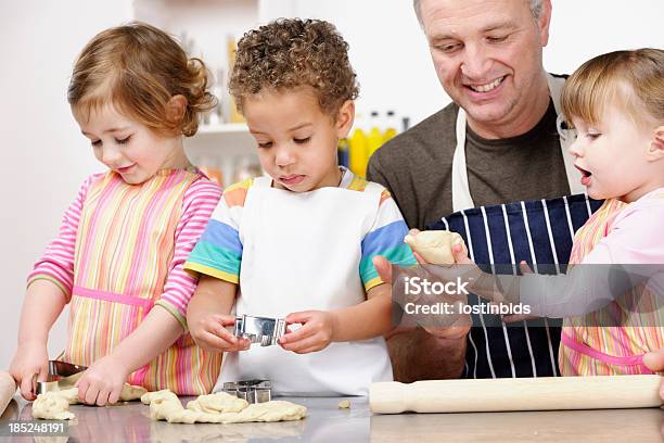 Grupo De Niños O Niños Pequeños Preparación De La Masa Con Sus Carer Foto de stock y más banco de imágenes de Cocinar