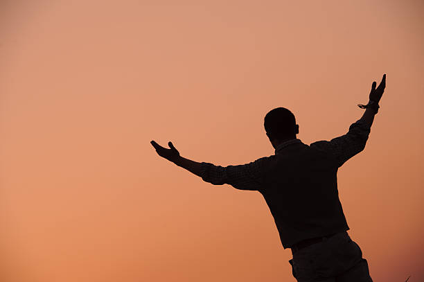 Silhouette of man Silhouette of spiritual man in sunset light. sing praise stock pictures, royalty-free photos & images