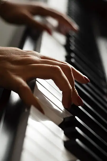 A pair of female hands playing the piano.