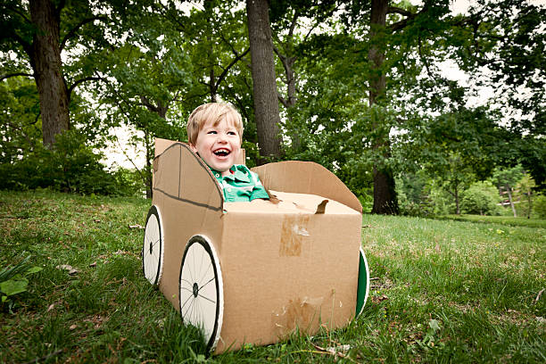 istock A little boy playing in a cardboard car outside 185249079