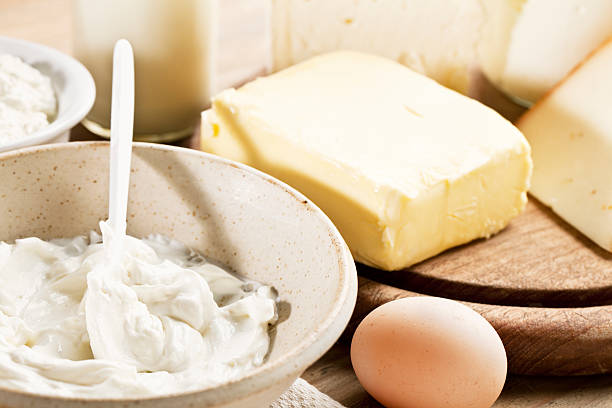 dairy products such as cheese, yoghurt, cottage cheese, milk in a glass bottle on wooden table, i
