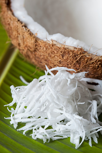 Fresh grated coconut on a tropical banana leaf, shallow depth of field, good copy space.