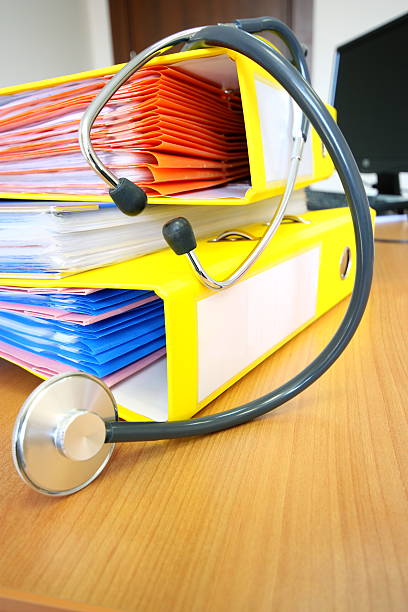 Doctor's Office Health records and a stethoscope. patient-filing-system stock pictures, royalty-free photos & images