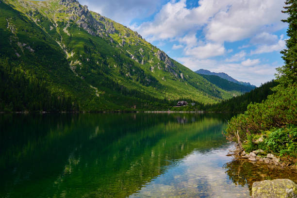 Mountains range near lake at summer day Amazing view on mountains range near beautiful lake at summer day. Tatra National Park in Poland. Panoramic view on Morskie Oko or Sea Eye lake in Five lakes valley zakopane stock pictures, royalty-free photos & images