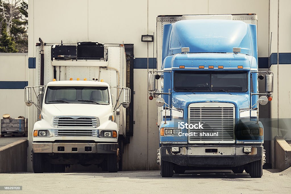 Tractor Trailers at Warehouse A 5 tonne long box truck and tractor trailer are loaded at a warehouse. Loading Dock Stock Photo