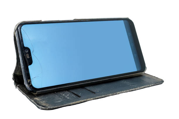 Used smart phone with cracked screen in a flip case, placed in horizontal position. Isolated on white background with clipping path