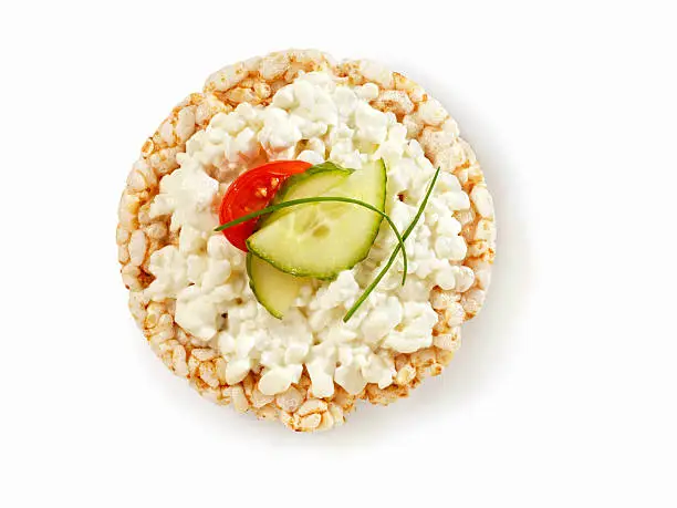 "A Whole Wheat Rice Cake Topped with Cottage Cheese, Cucumber, a Cherry Tomato and fresh Chives with Natural Drop Shadow- Photographed on Hasselblad H3D2-39mb Camera"